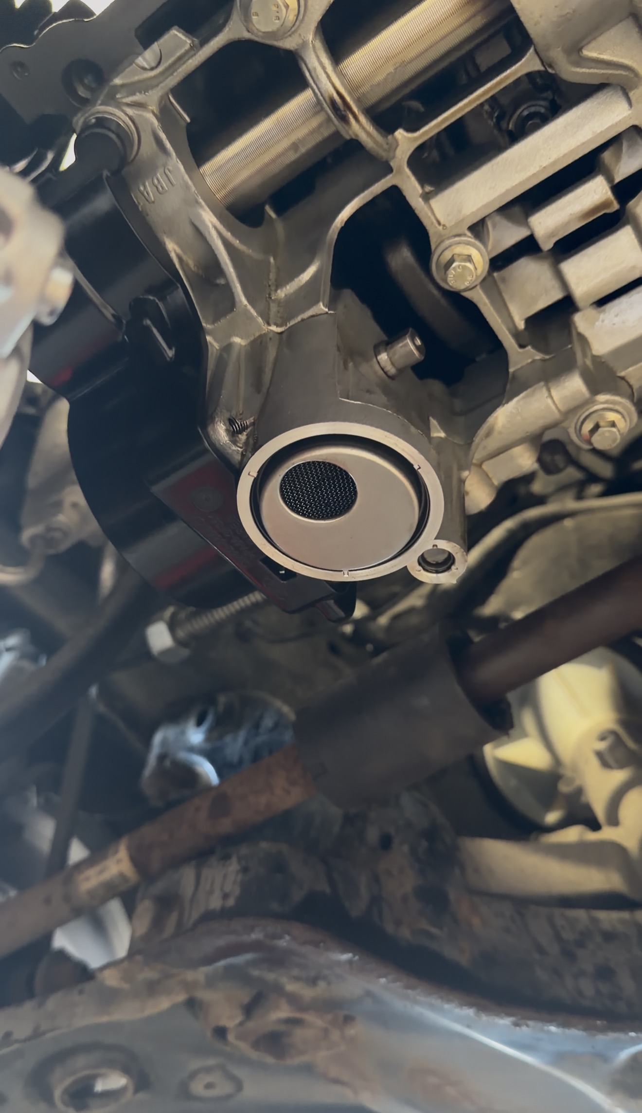Oil pump strainer showing debris contamination from wet belt degradation